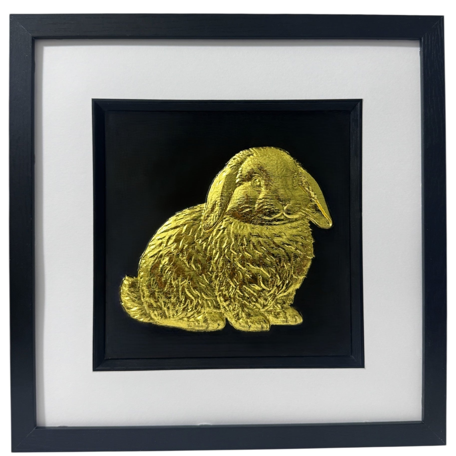 Framed Mini Lop rabbit 3D wall art in gold leaf, in a black wooden frame with white mount on a black background.