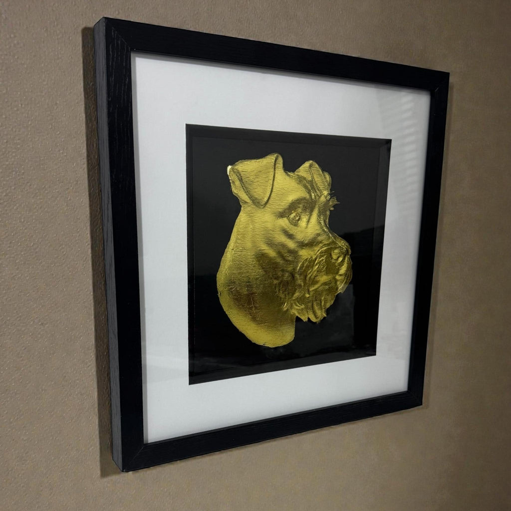 Miniature Schnauzer gold leaf framed wall art mounted on a wall shown at a slight angle with black frame and white mount