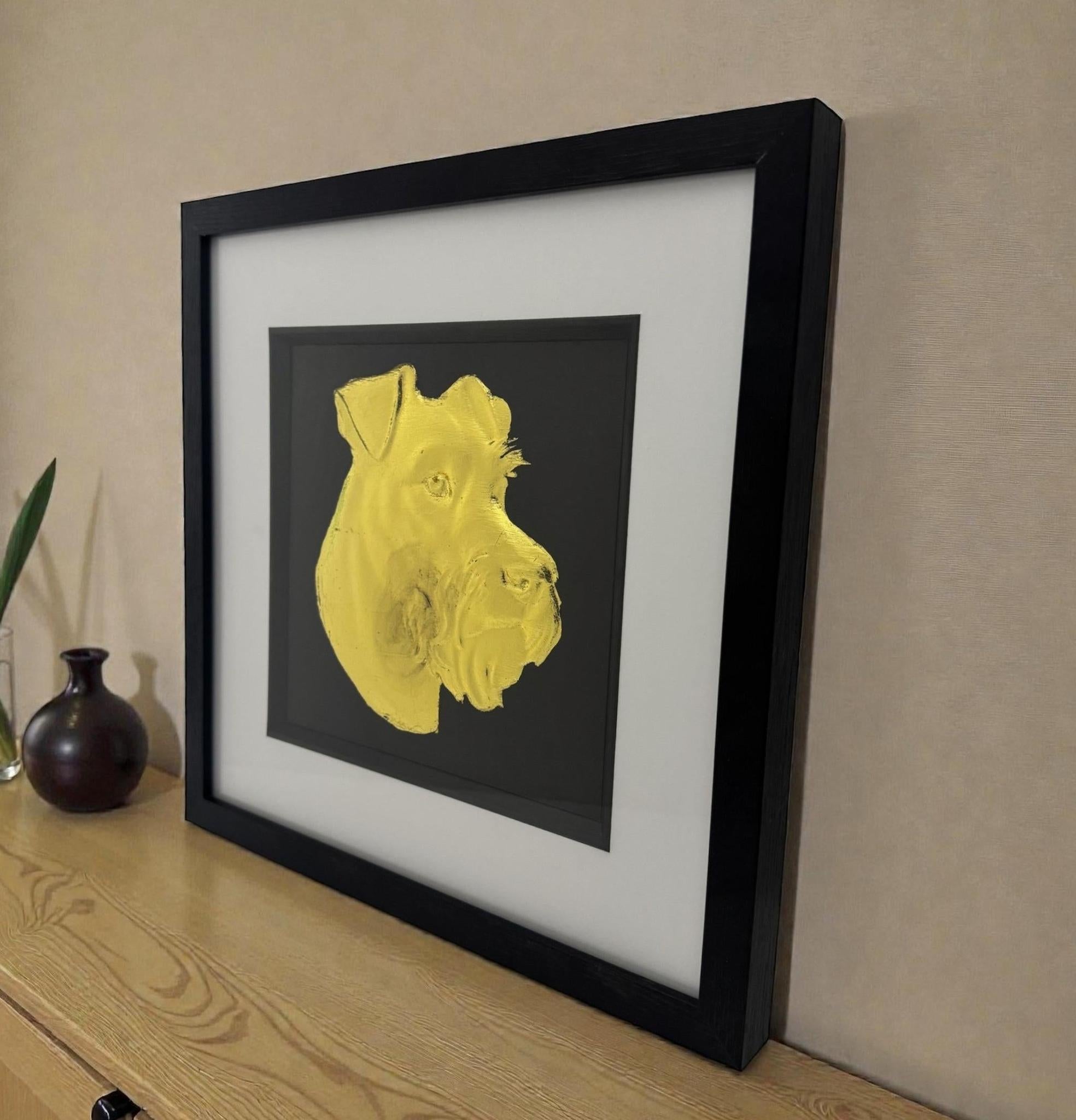 Miniature Schnauzer gold leaf wall art photographed at an angle on a shelf with black frame and white mount