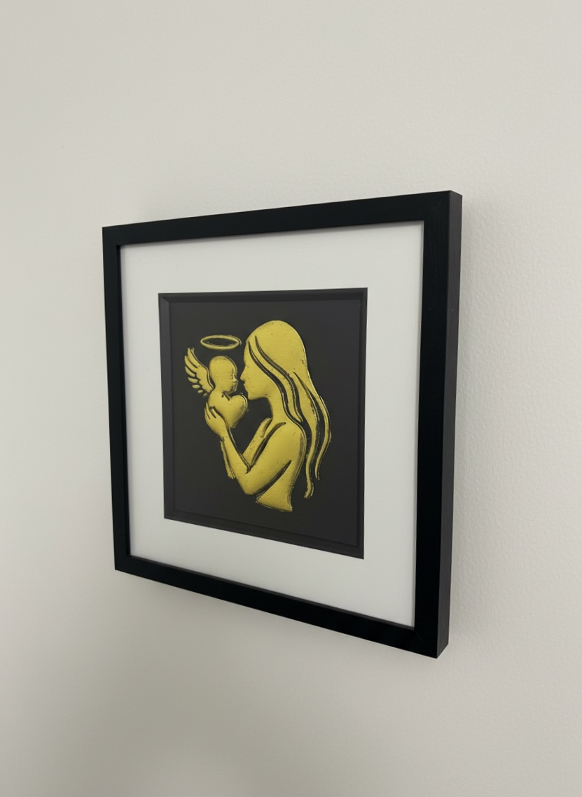 Wall-mounted mother and baby angel wall art framed in black with white mount