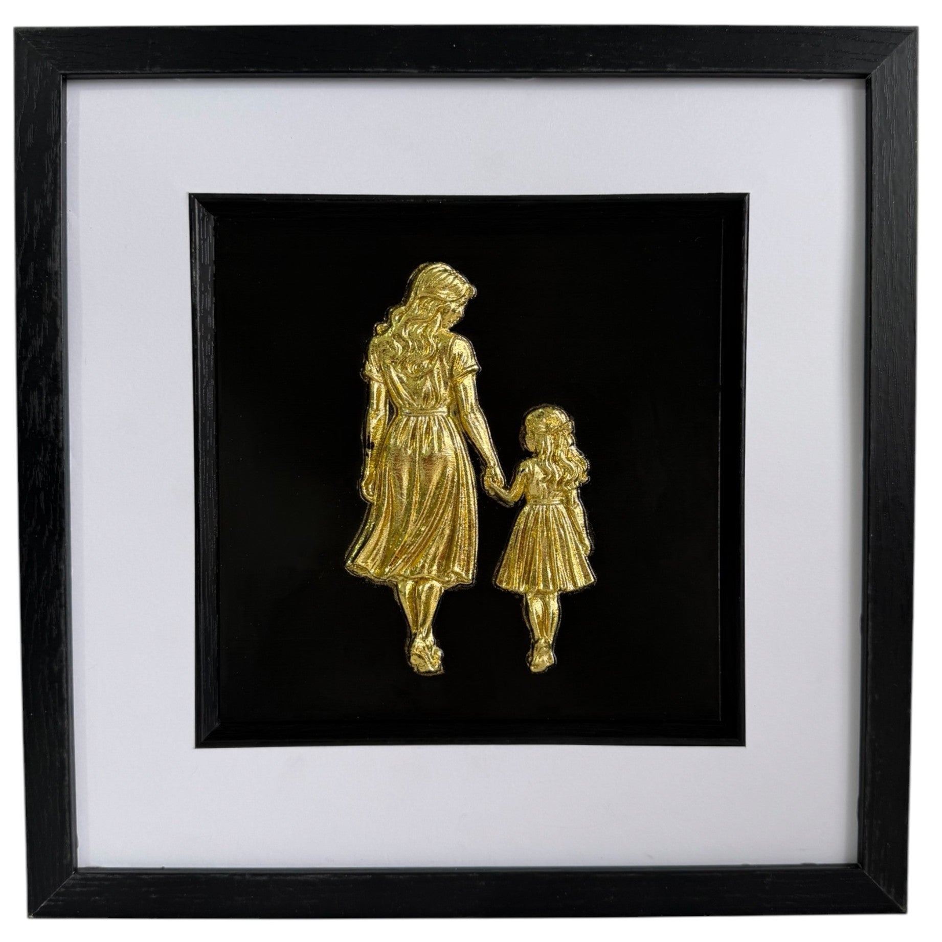Straight-on Gold mother and daughter relief artwork with glass front, black frame and white mount.