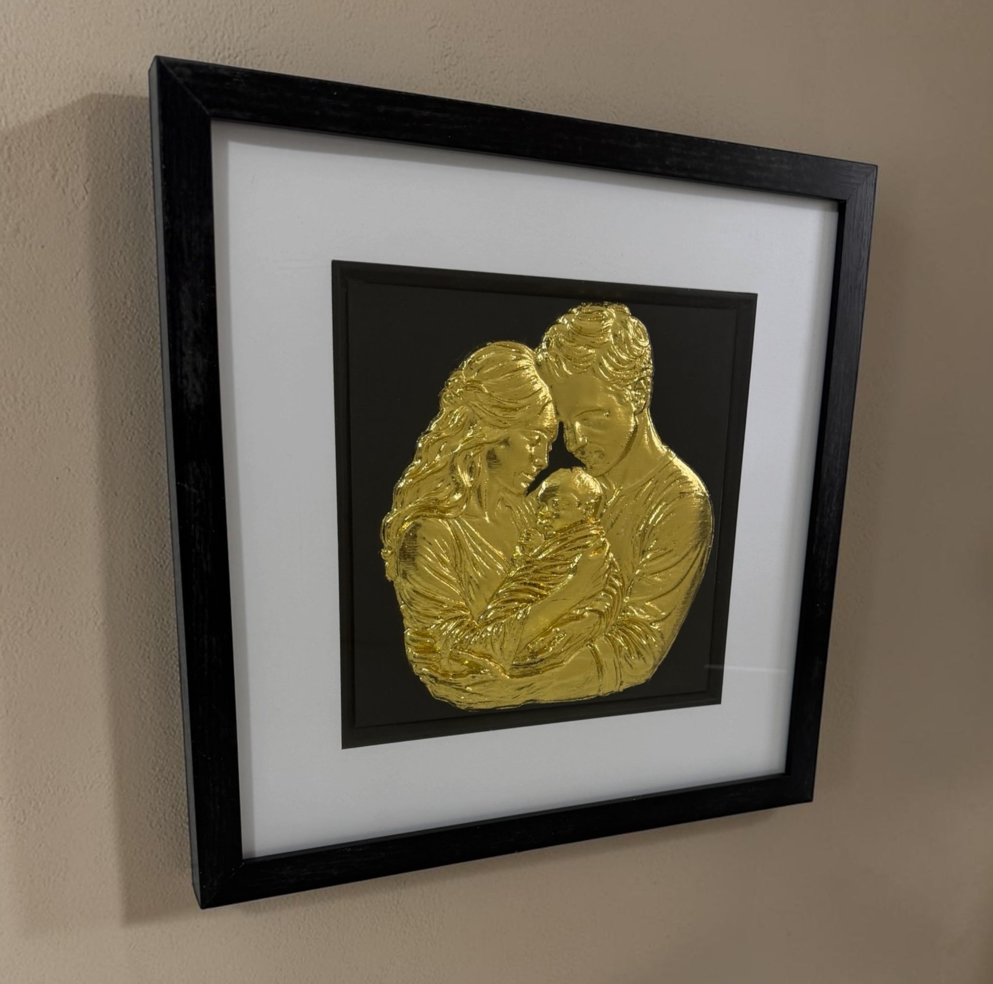 Angled Gold finish family relief artwork showing black box frame, white mount and glass front.