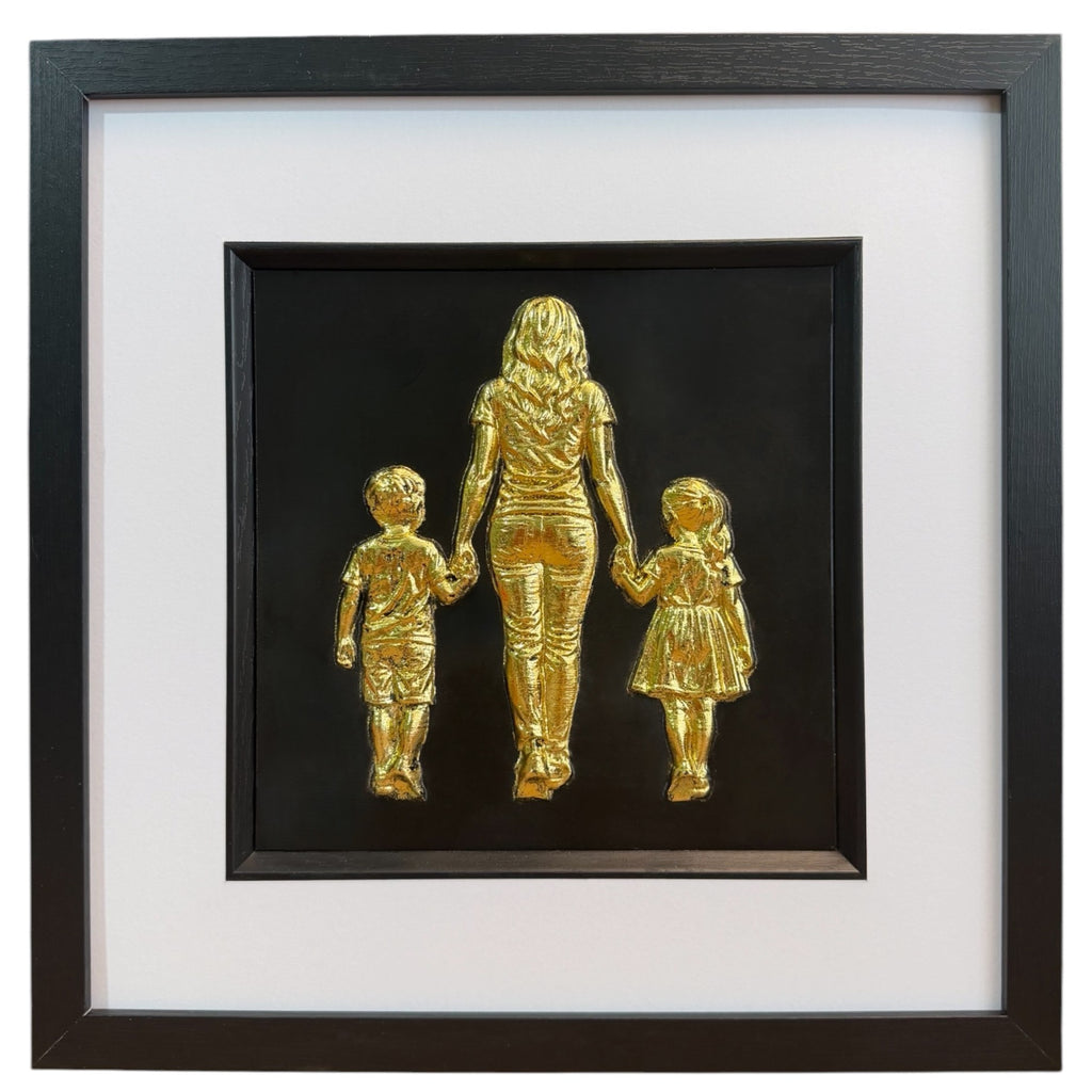 Mum, son and daughter framed wall art showing three sculpted figures walking hand in hand in gold leaf, set on a black background with white mount and black wooden frame