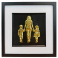Mum, son and daughter framed wall art showing three sculpted figures walking hand in hand in gold leaf, set on a black background with white mount and black wooden frame