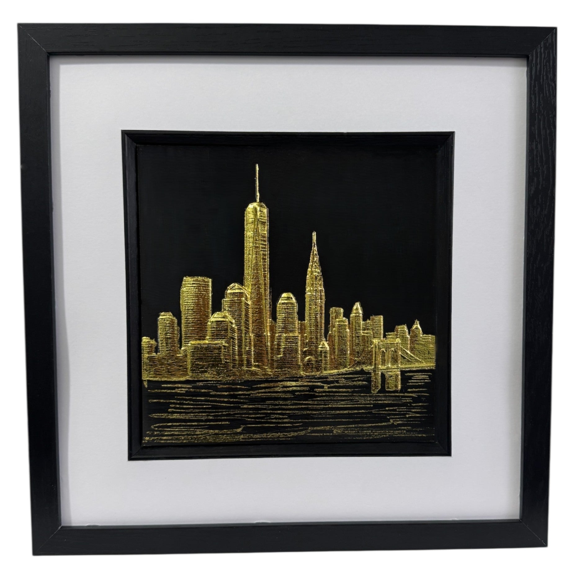 Framed New York skyline wall art in gold leaf, front view showing city silhouette above water on black background