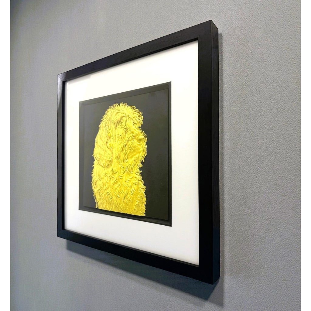 Otterhound framed wall art in gold leaf shown mounted on a wall at a slight angle with black wooden frame and white mount