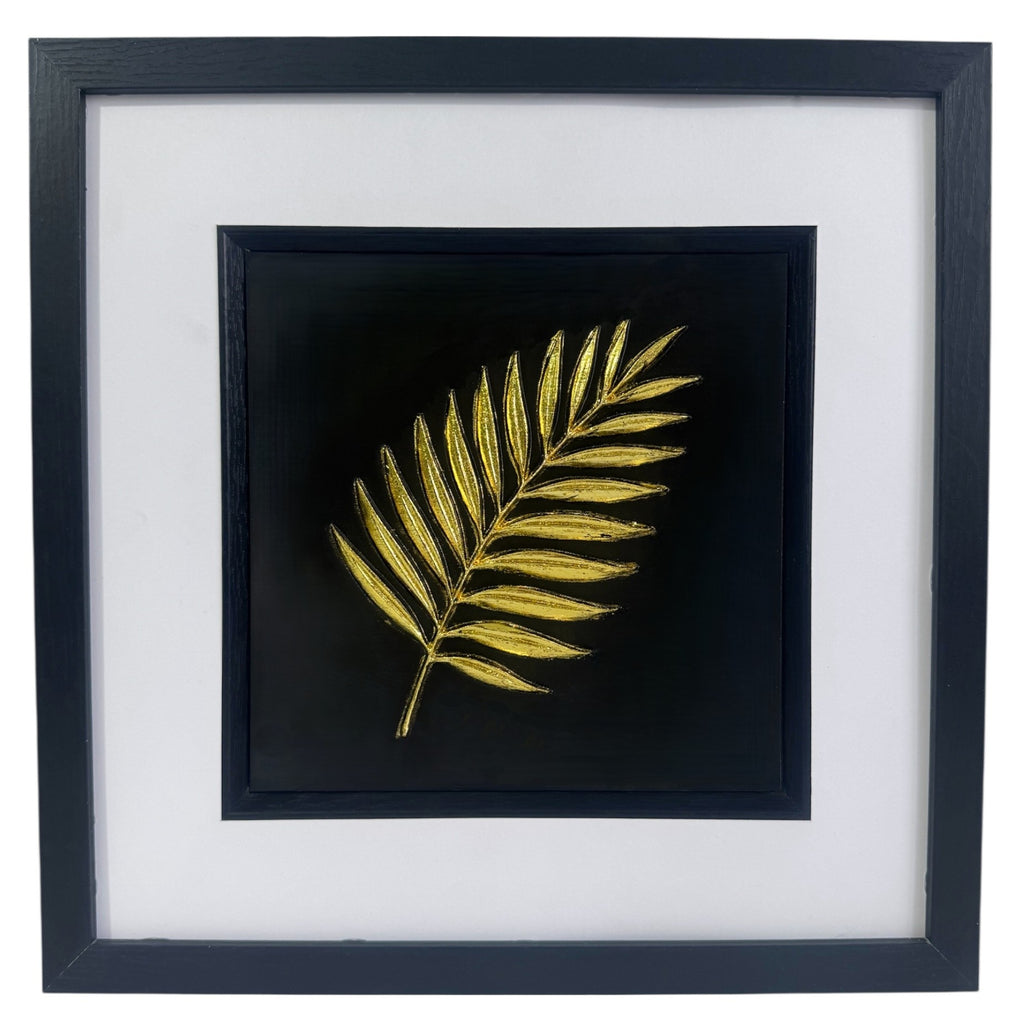 Gold palm leaf wall art framed in black with white mount, raised relief palm leaf on a deep black background