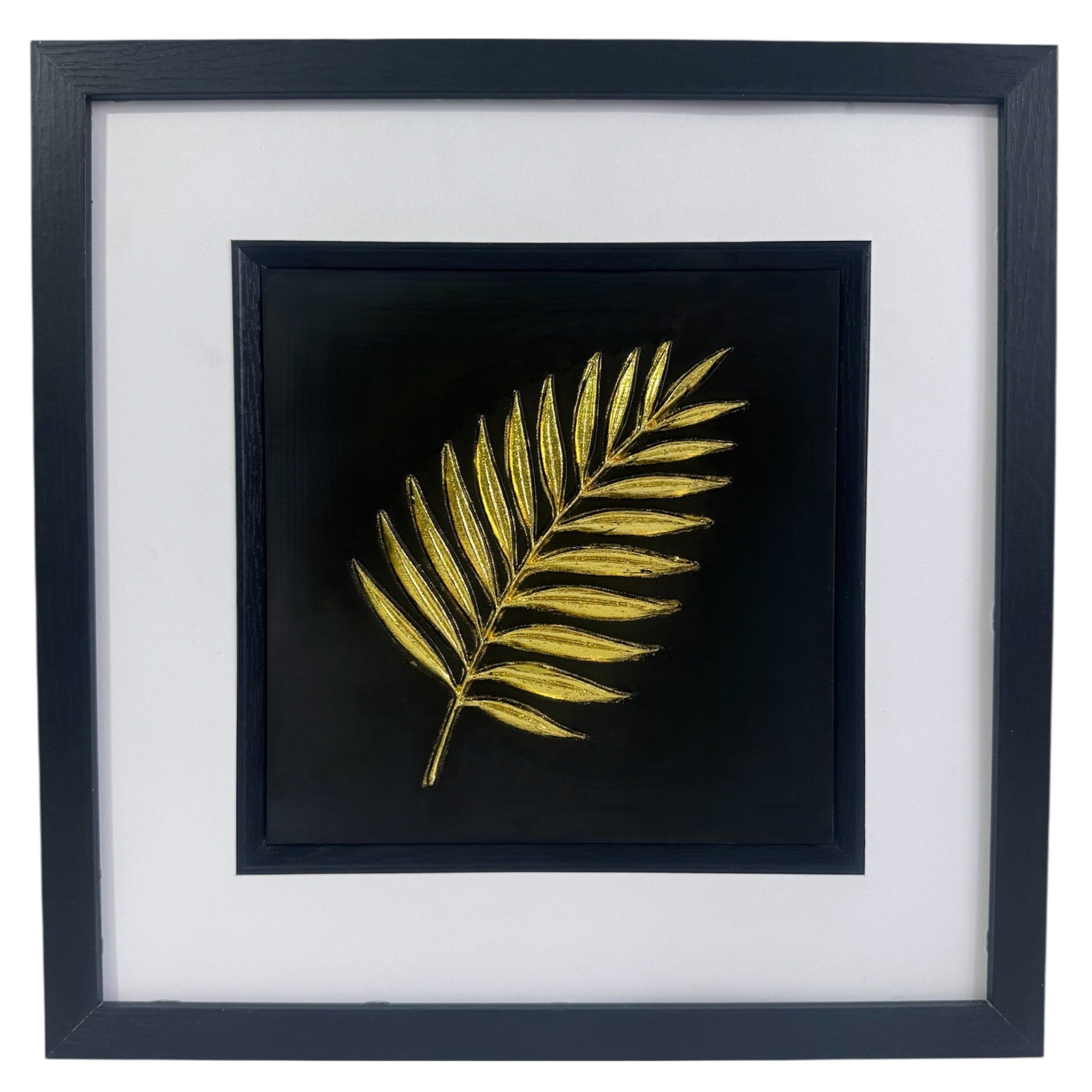 Gold palm leaf wall art framed in black with white mount, raised relief palm leaf on a deep black background