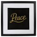 Gold framed Peace word artwork with raised script lettering, black centre, white mount and black square frame.