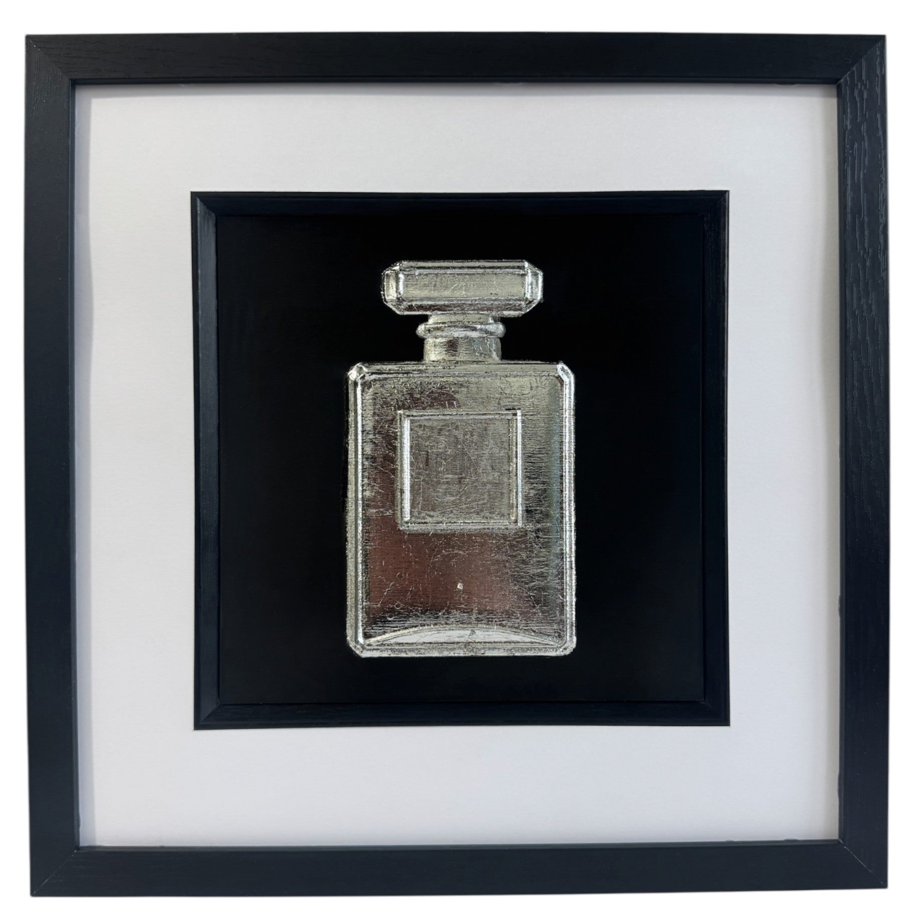 Perfume bottle wall art in silver leaf with raised relief bottle design on a black background, black frame with white mount