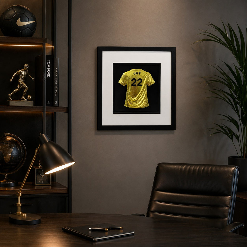 Framed personalised gold leaf football shirt wall art with custom name and number displayed on a modern home office wall.