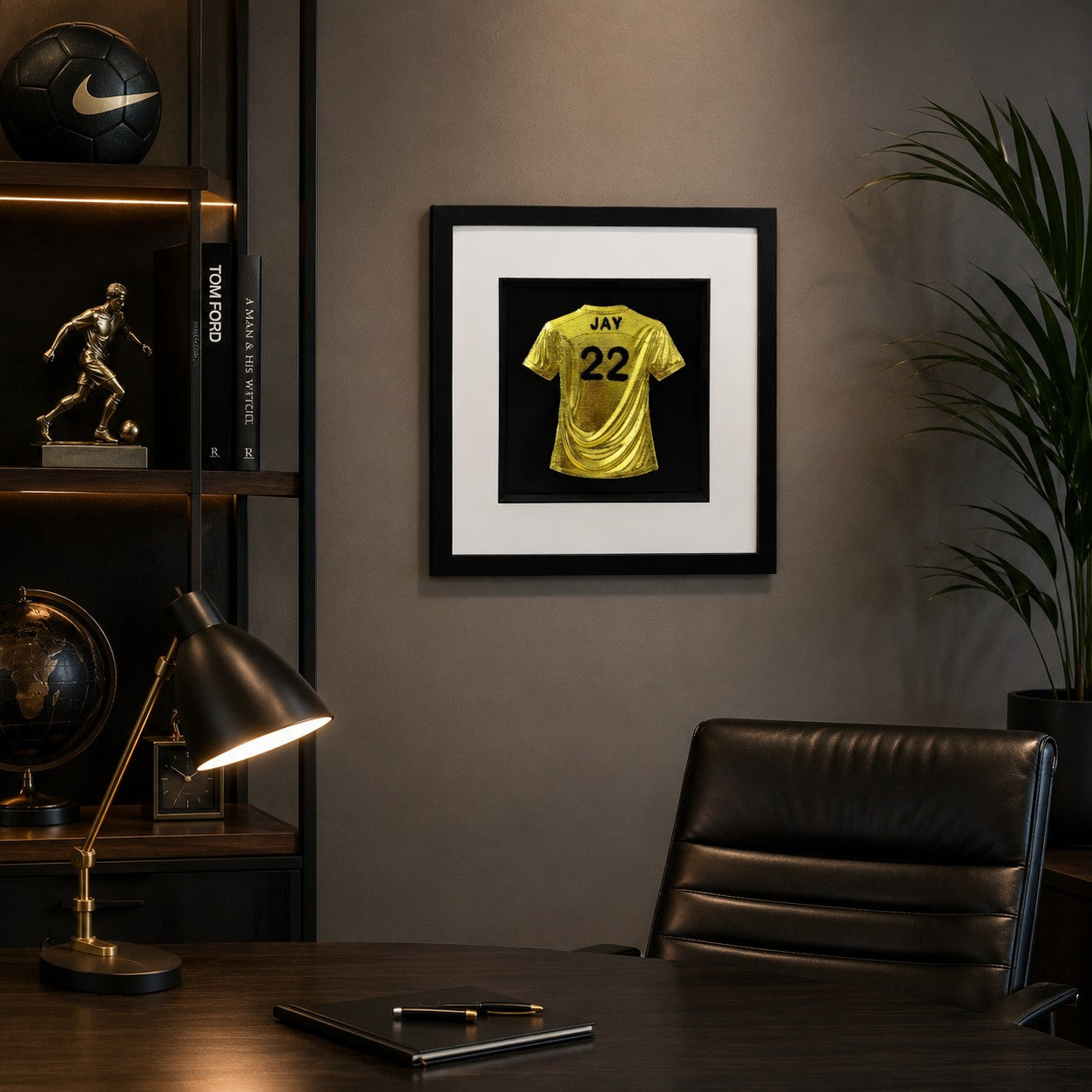 Framed personalised gold leaf football shirt wall art with custom name and number displayed on a modern home office wall.