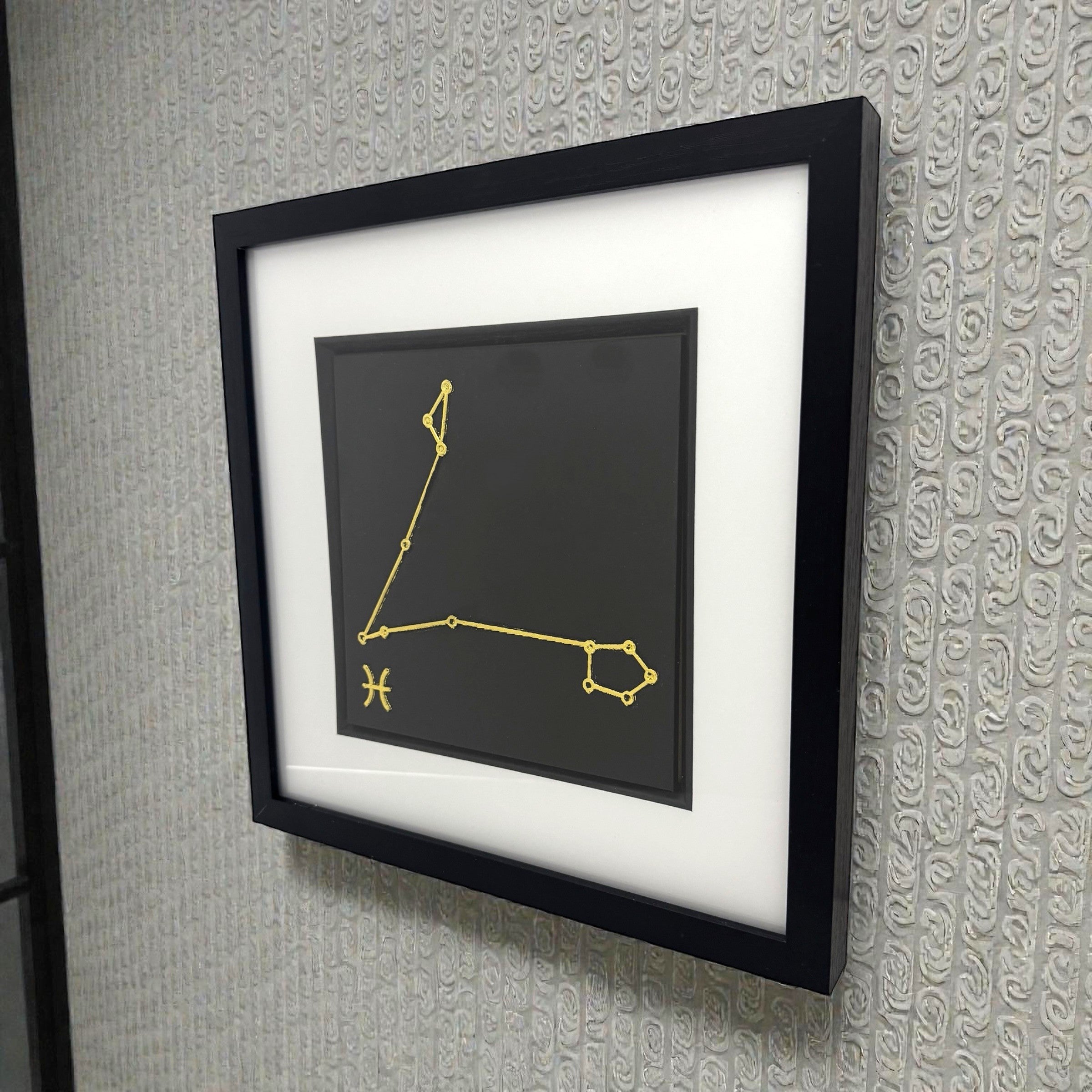 Pisces constellation wall art displayed on wall in black frame