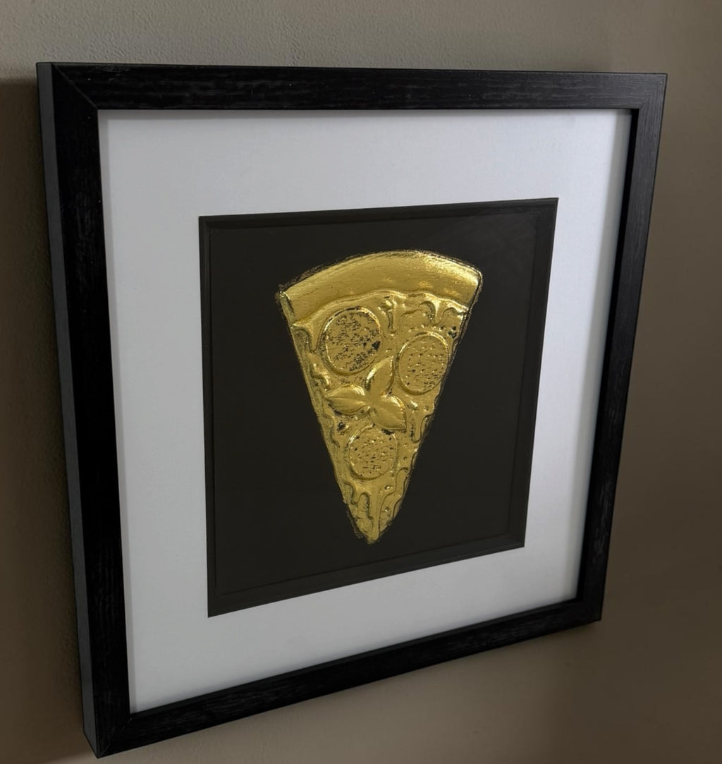 Angled Gold pizza slice framed artwork showing raised relief detail, black background and white mount.