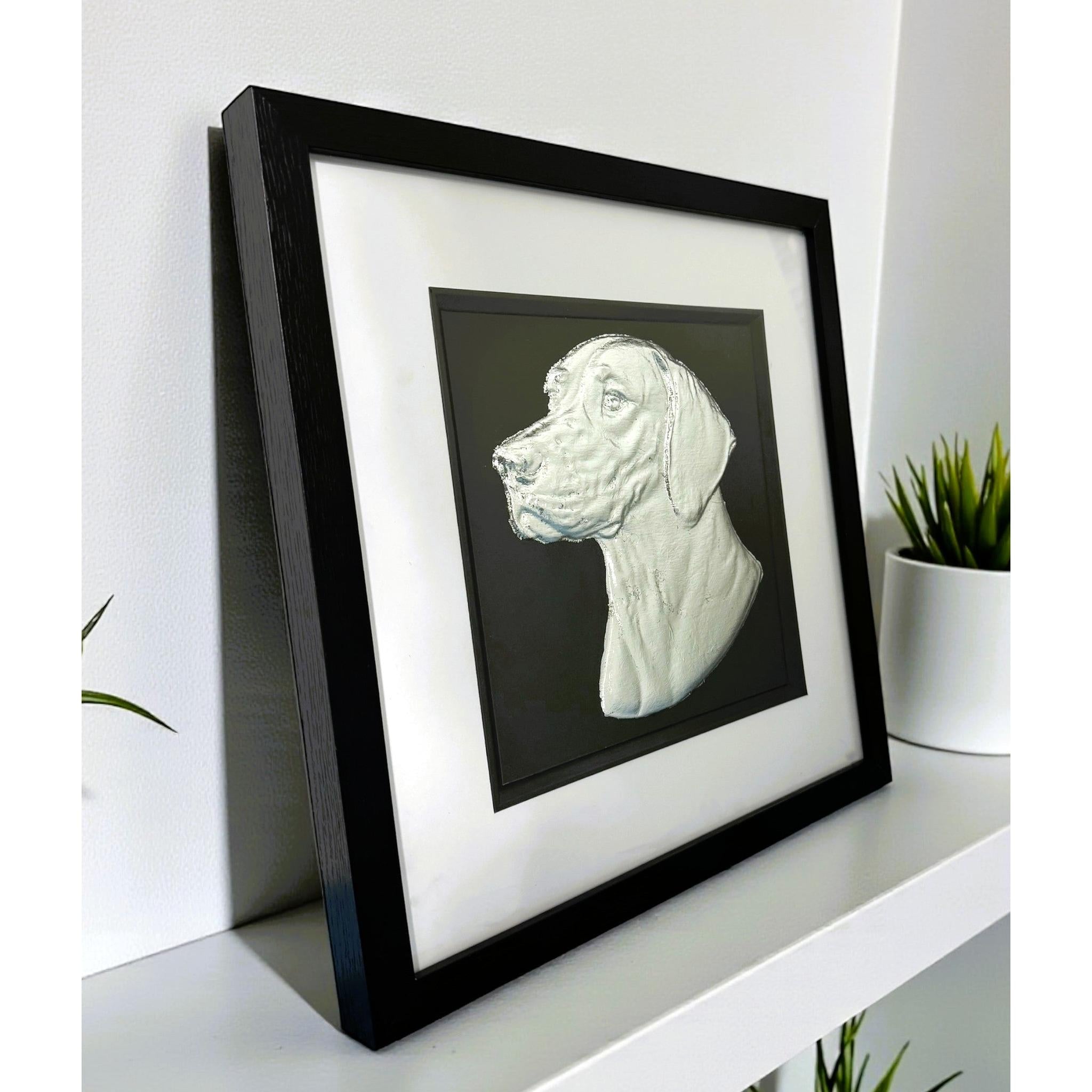 English Pointer framed wall art in silver leaf viewed at an angle, displayed in a black wooden frame with white mount
