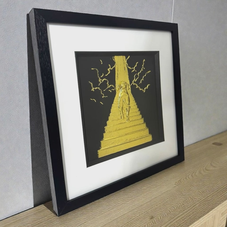 Slow pan video of a framed Dog Stairway to Heaven wall art on a wooden surface, finished in gold leaf, with a black frame and white mount.