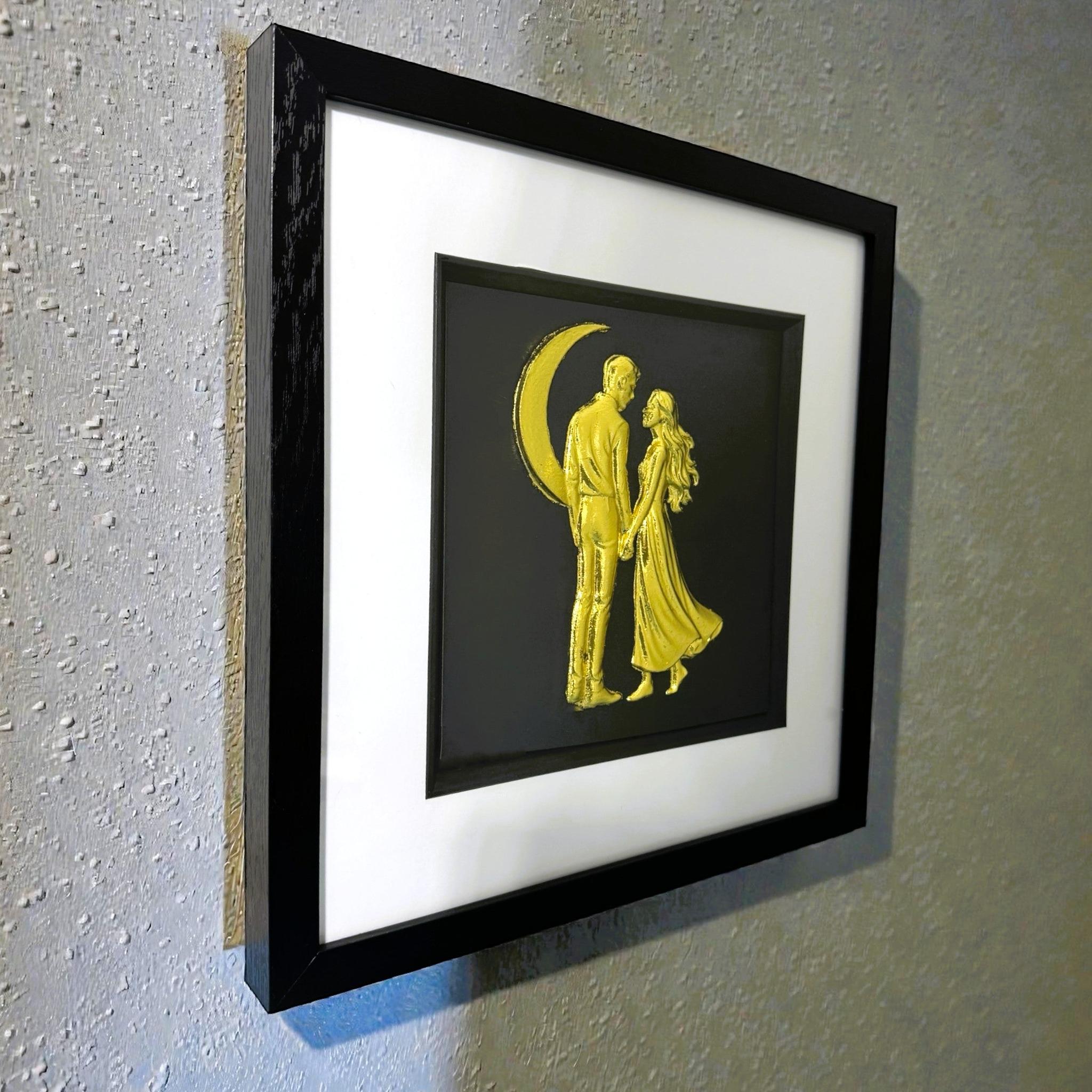 Angled wall-mounted view of romantic couple under the moon wall art in a black frame
