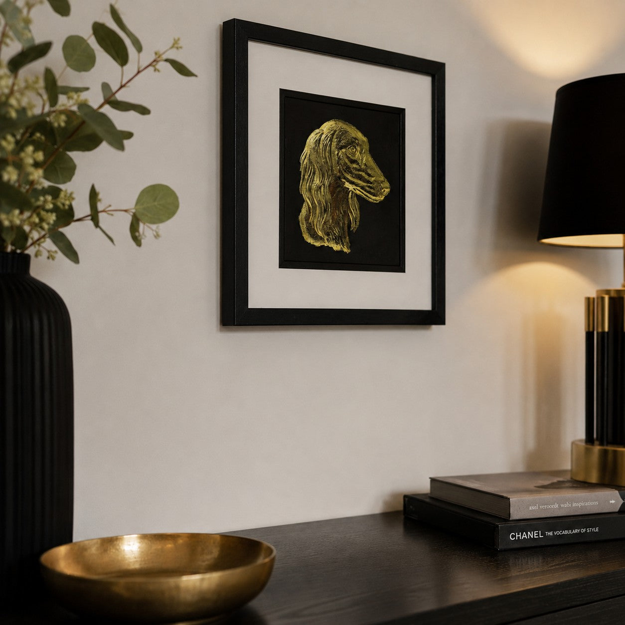 Angled view of Saluki gold leaf framed dog wall art styled in a modern home interior with black frame, white mount, and luxury gold accents.