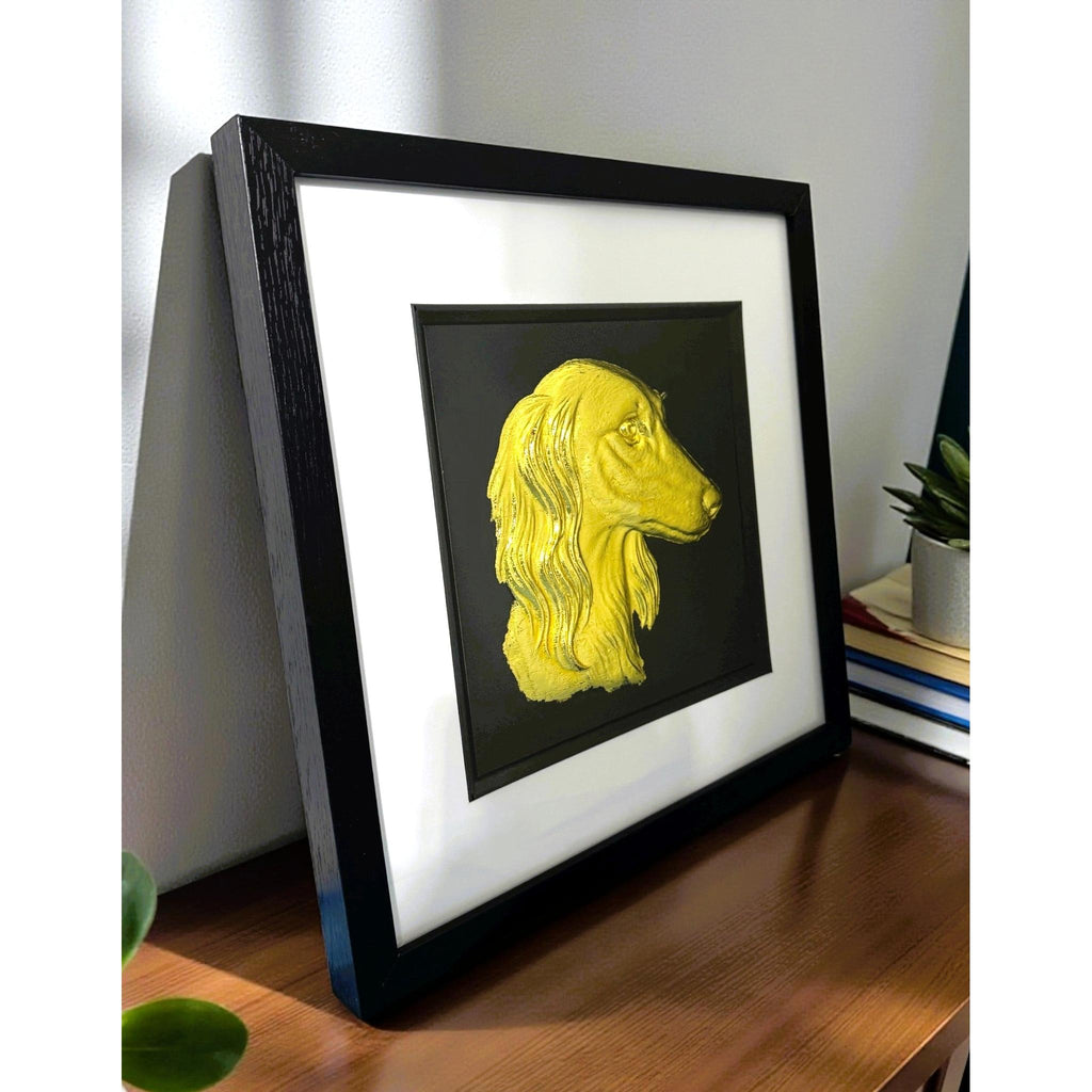Saluki gold leaf wall art photographed at an angle on a desk with black frame and white mount