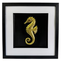 Gold seahorse wall art framed in black with white mount, raised relief seahorse on a deep black background