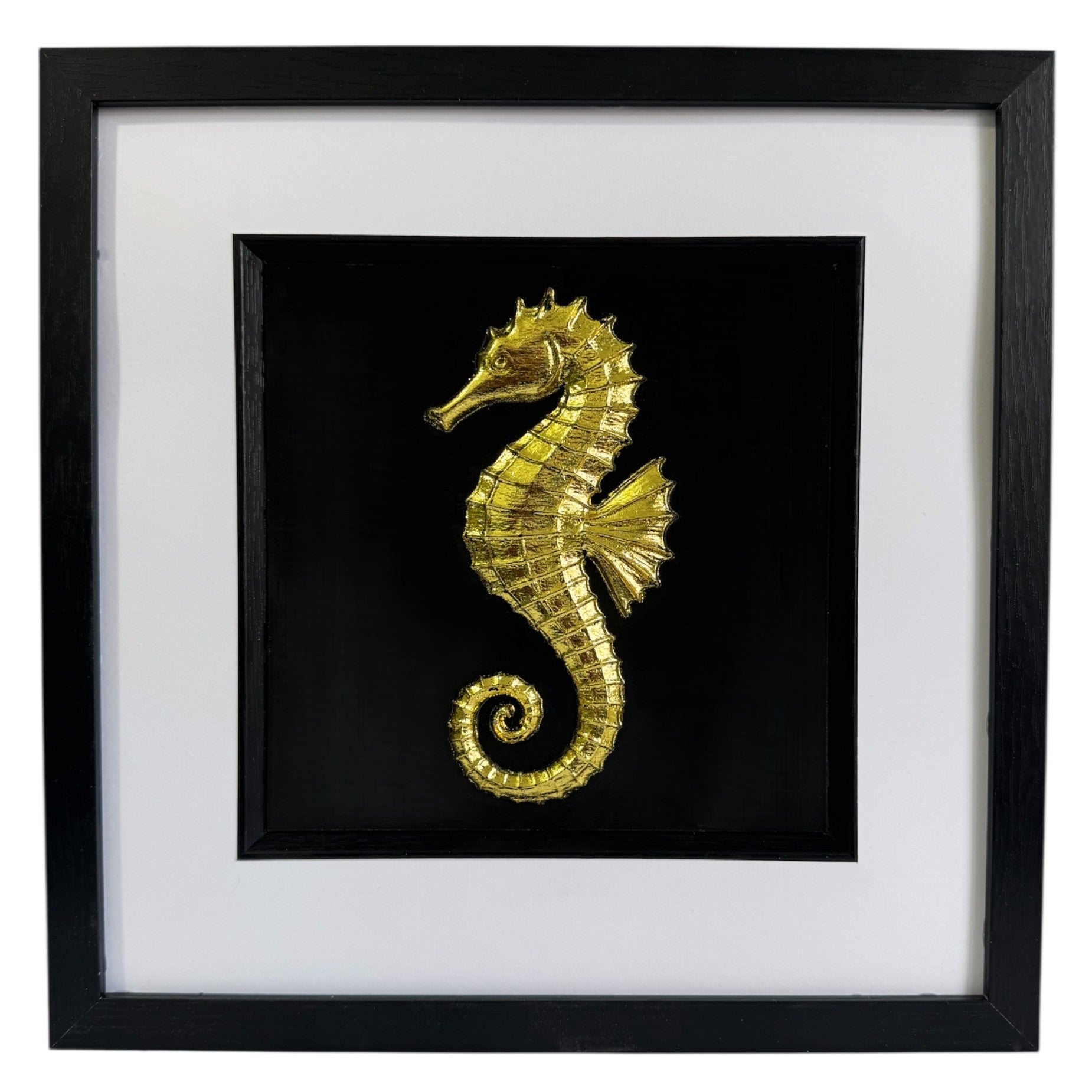 Gold seahorse wall art framed in black with white mount, raised relief seahorse on a deep black background