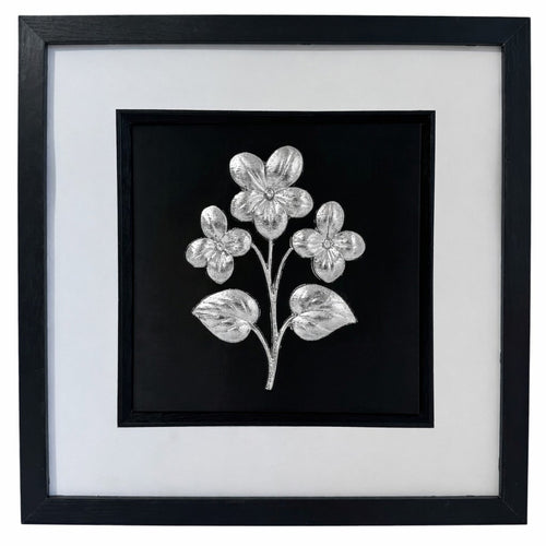 Silver framed floral relief with three flowers and two leaves on a black background with a wide white mount and black inner surround