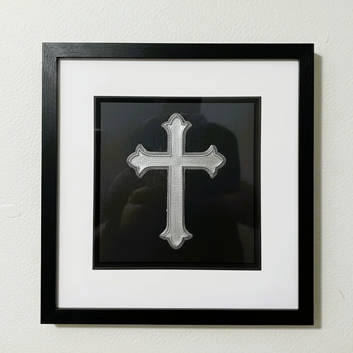 Silver leaf cross wall art framed in black wood with white mount, shown straight on against a neutral wall