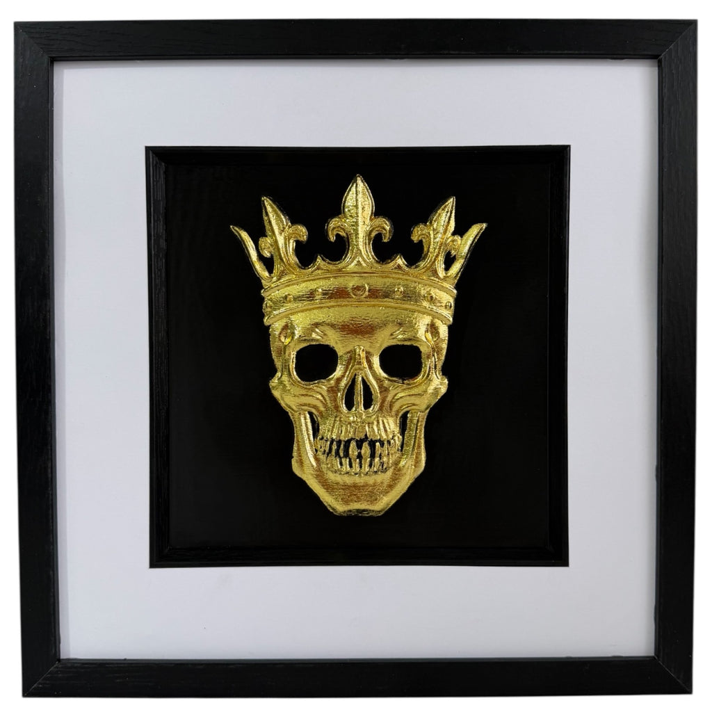 Gold crowned skull artwork with raised relief, black centre, white mount and black square frame.