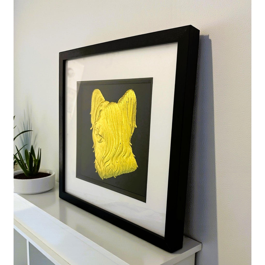 Skye Terrier gold leaf wall art photographed at an angle on a shelf with black frame and white mount