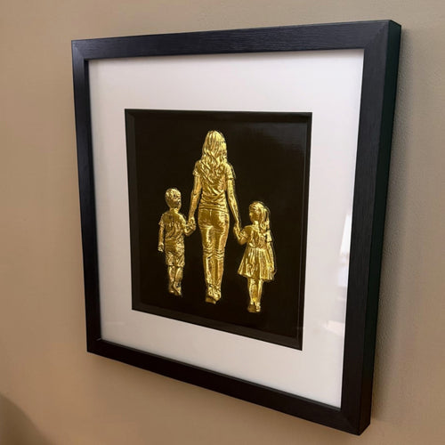 Mum, son and daughter framed wall art in gold leaf mounted on a wall, with black wooden frame, white mount and black background