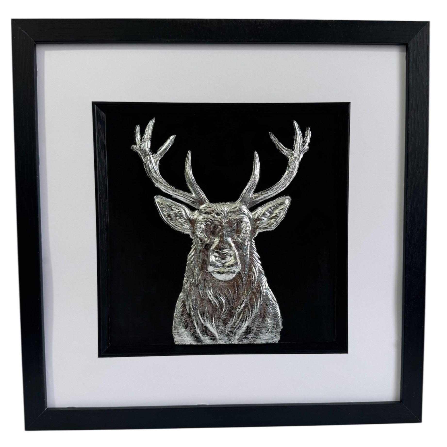 Silver stag wall art centred in black frame with white mount on a light background