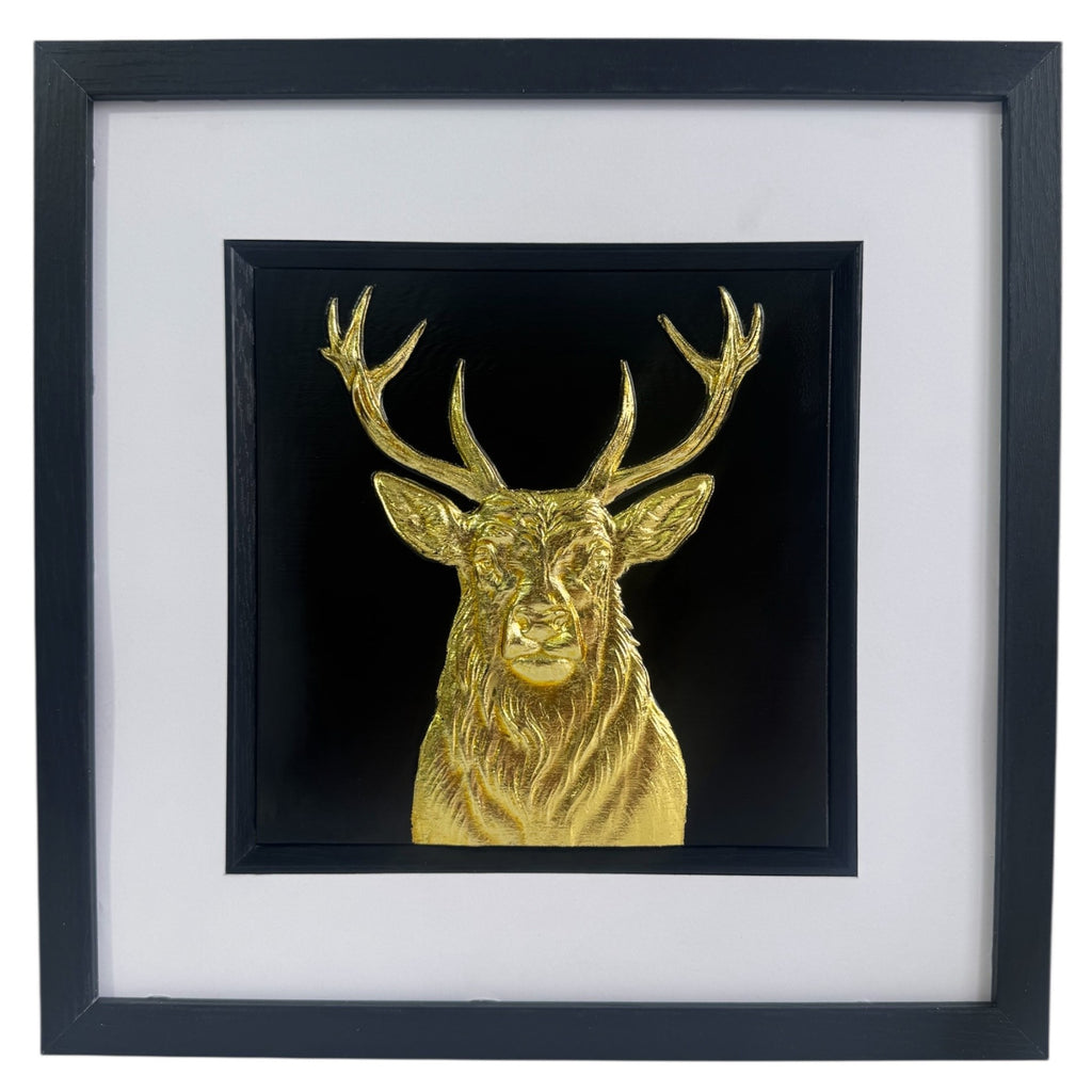Gold stag wall art centred in black frame with white mount on a light background