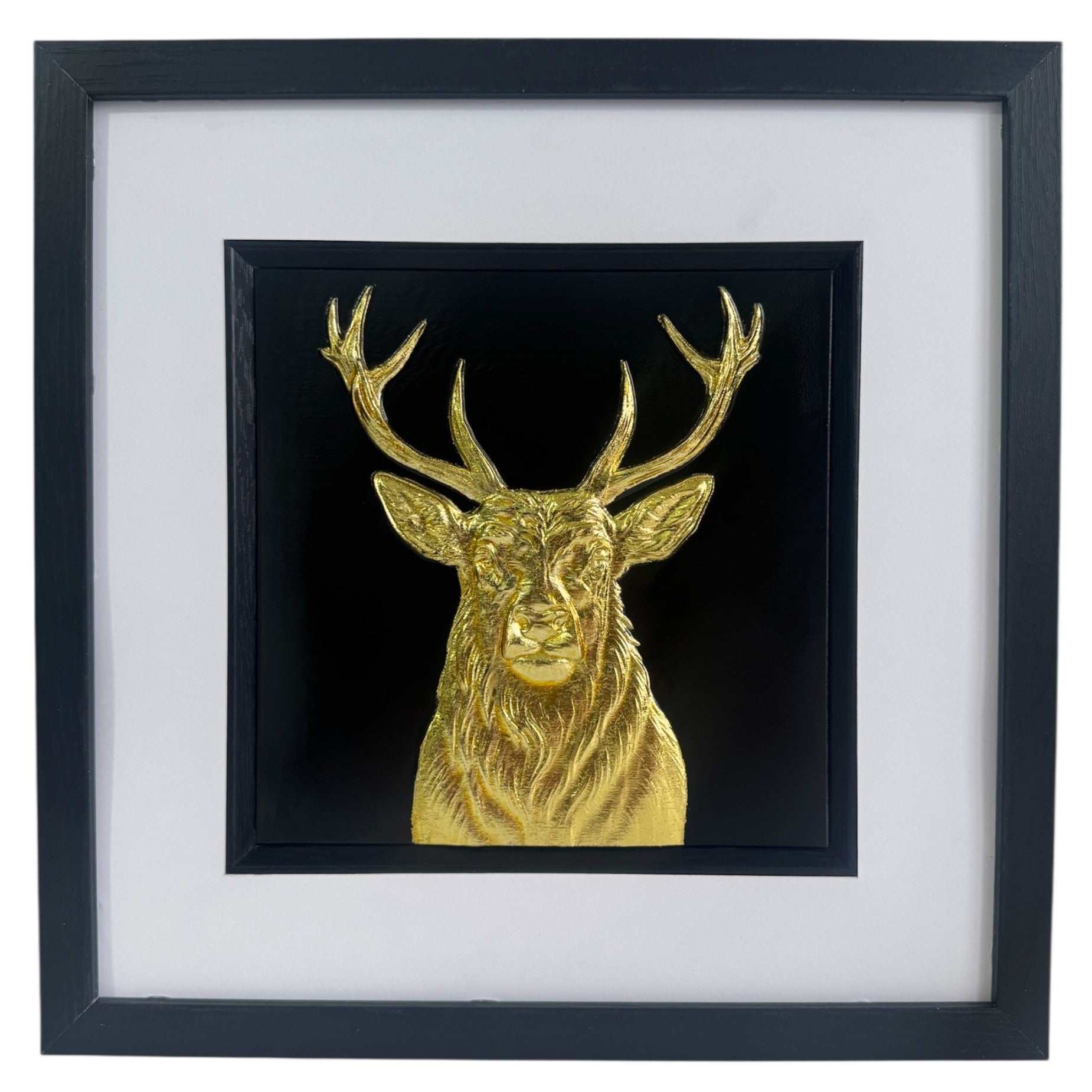 Gold stag wall art centred in black frame with white mount on a light background
