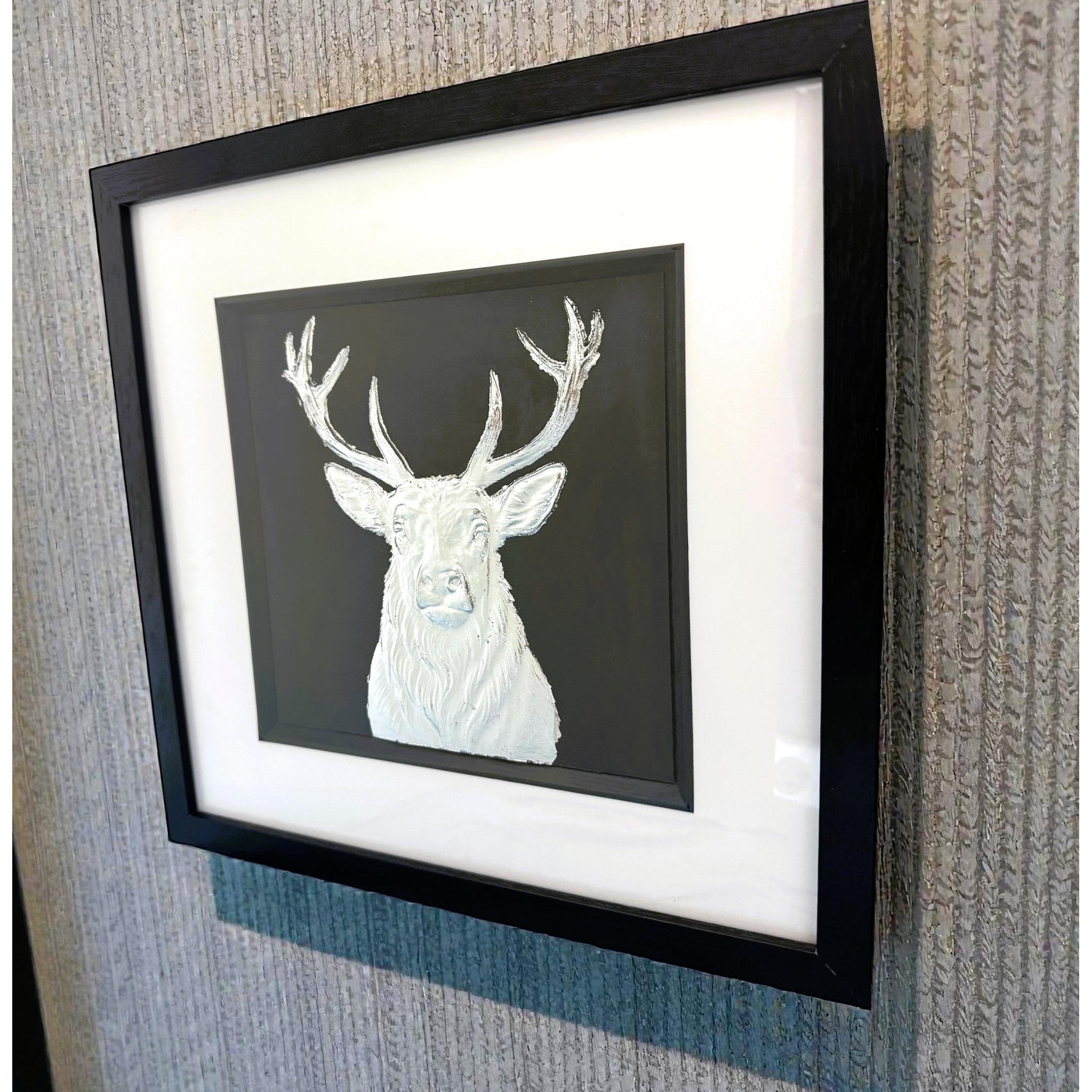Framed silver stag wall art shown from an angled wall view