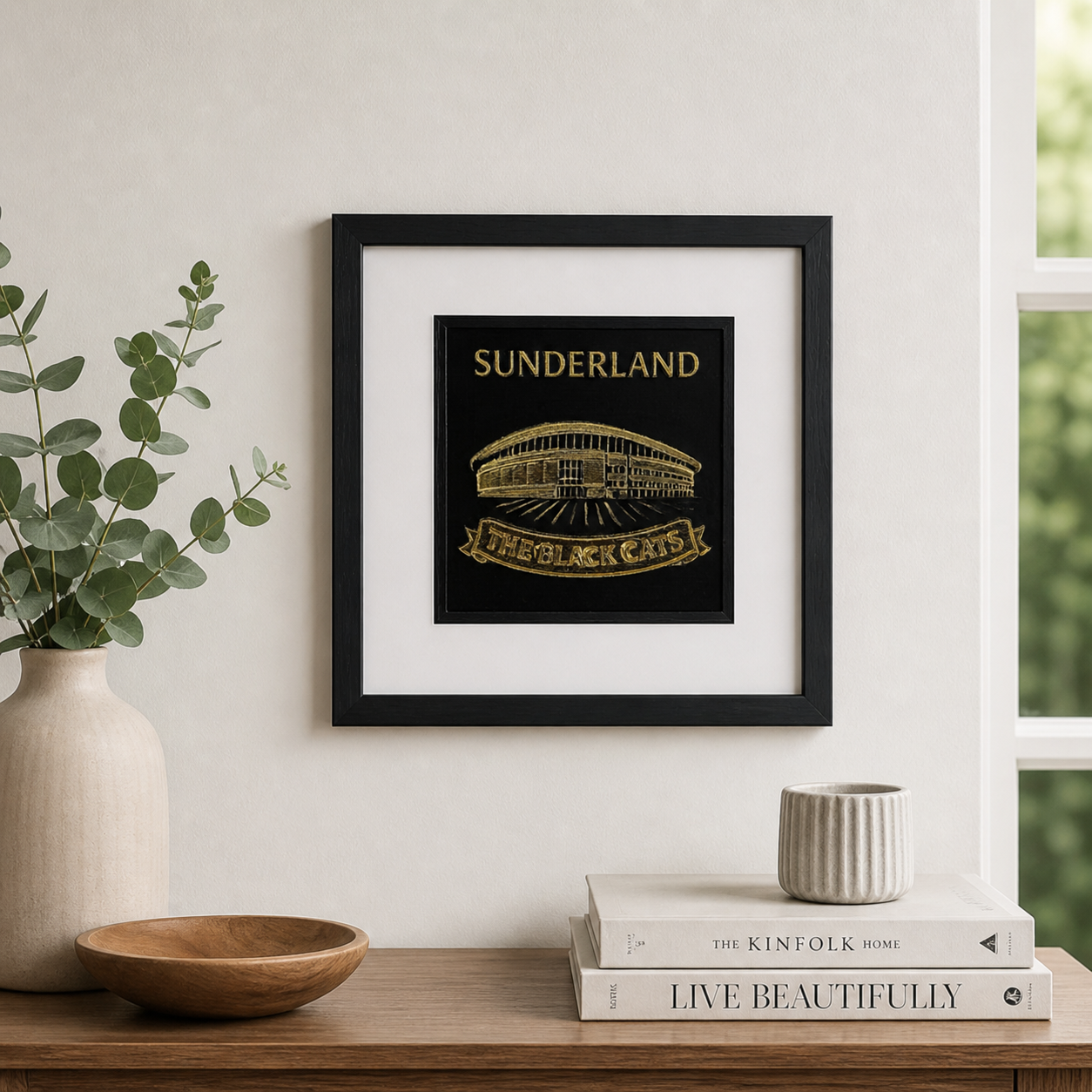Lifestyle photo of Sunderland AFC Stadium of Light wall art displayed on a neutral wall above a wooden sideboard with home decor.