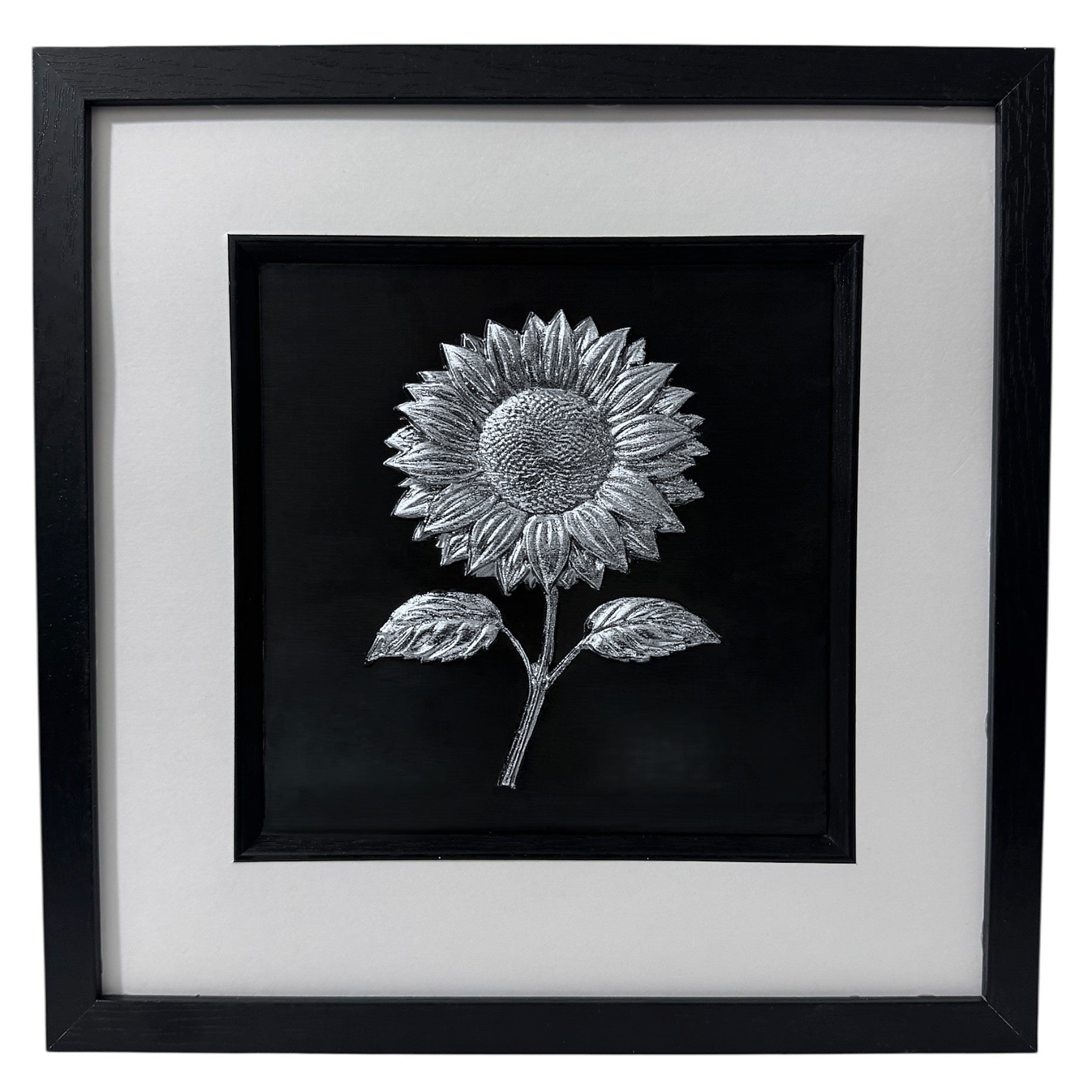 Silver Leaf sunflower relief artwork in a square black box frame with white mount and inner black surround, front view on white background