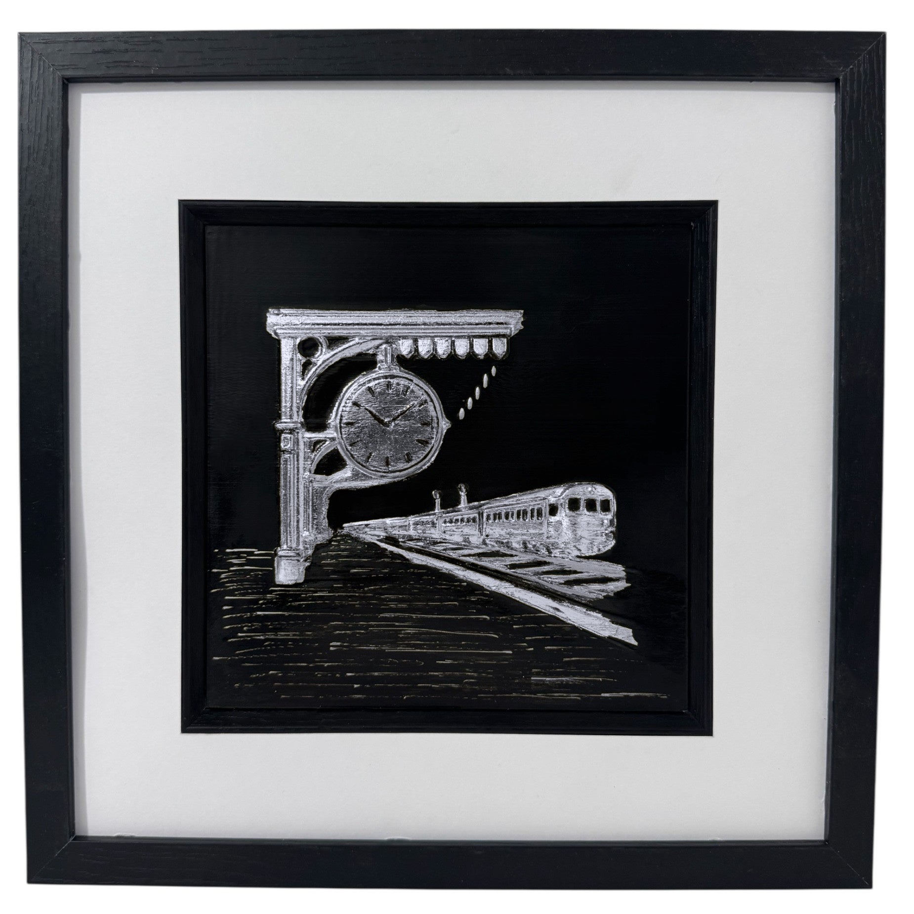 Silver train wall decor showing a station clock and departing train in a black box frame.