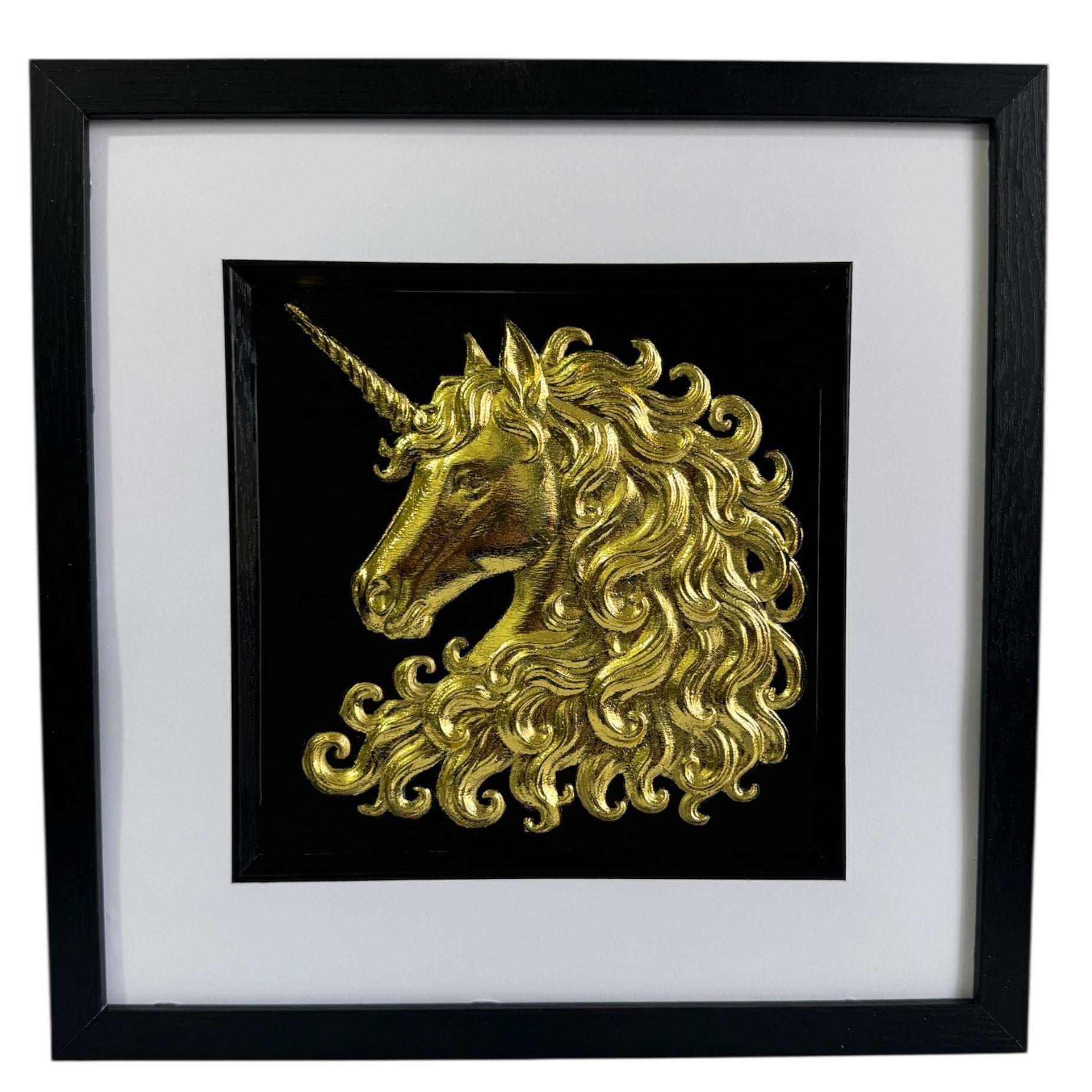 Framed unicorn wall art in gold leaf with raised relief unicorn head on a black background, black frame with white mount