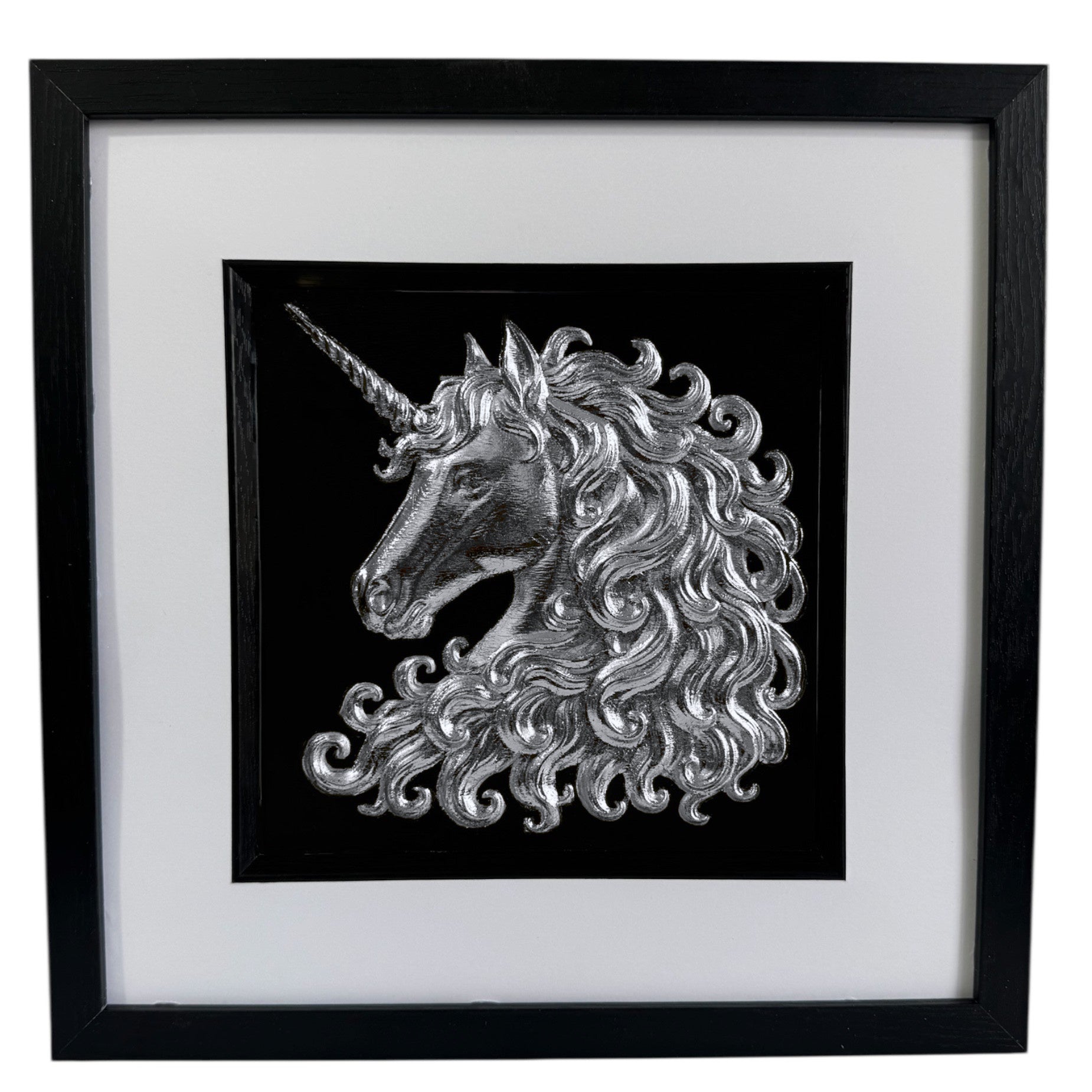 Framed unicorn wall art in silver leaf with raised relief unicorn head on a black background, black frame with white mount