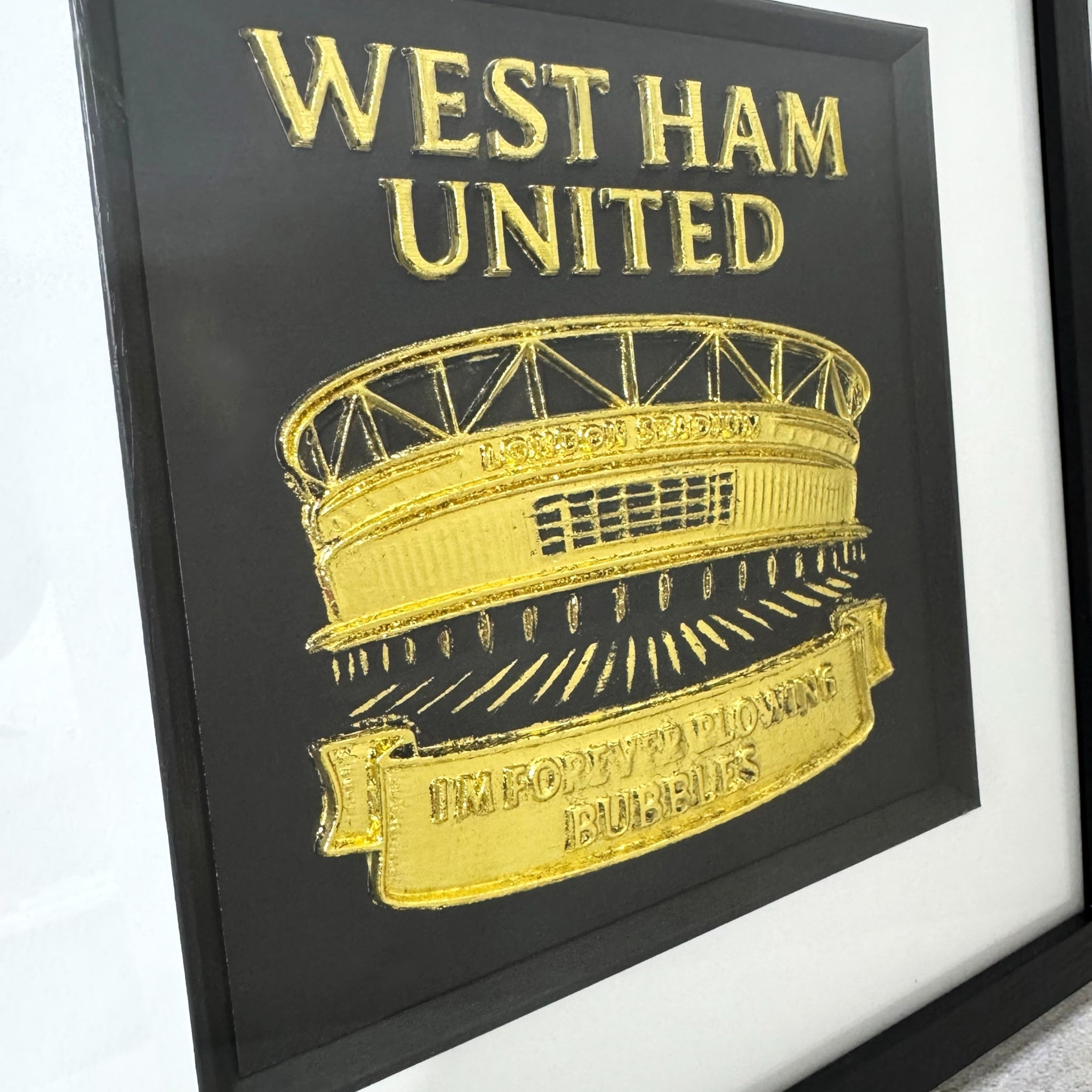 Close up of West Ham United London Stadium raised relief wall art in gold leaf with Im Forever Blowing Bubbles banner