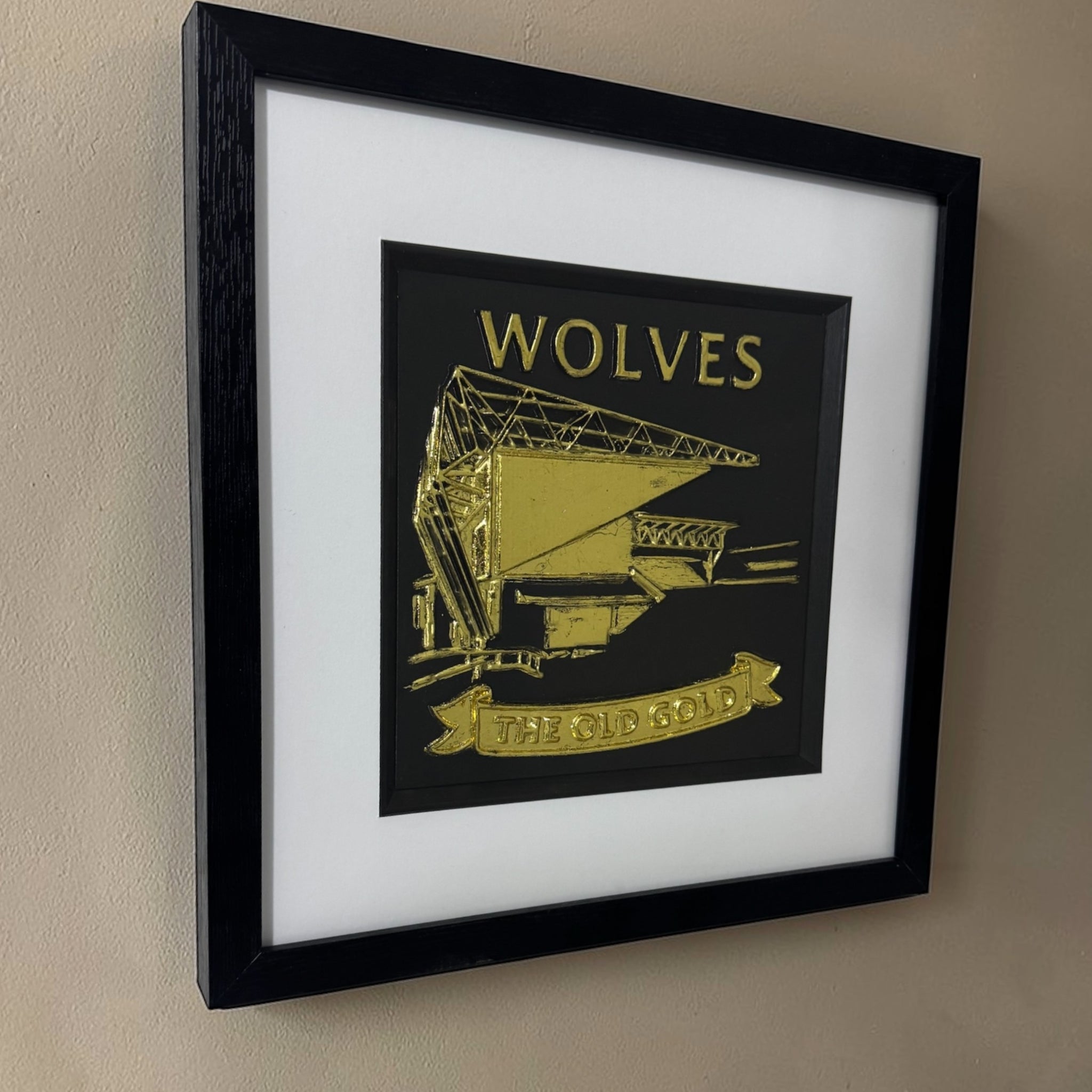 Gold Wolves 3D relief stadium artwork in black square frame with white mount, angled view on wall